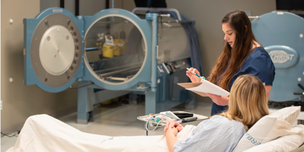 Patient talking to nurse before being put into a hard shell hyperbaric chamber