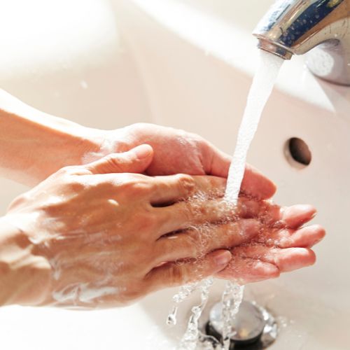 person washing their hands with soap